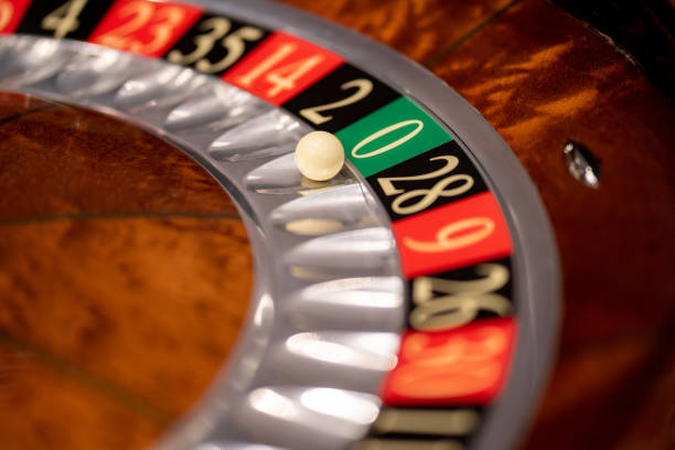 Close up of roulette wheel with ball on zero at the casino