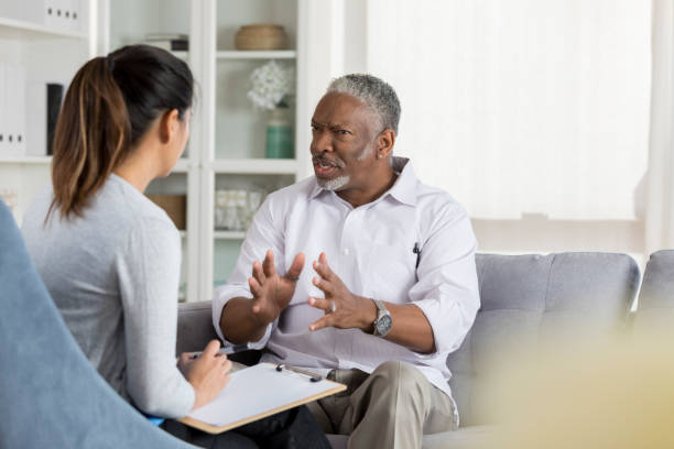 istock Senior man speaks intently with counselor 1032209794