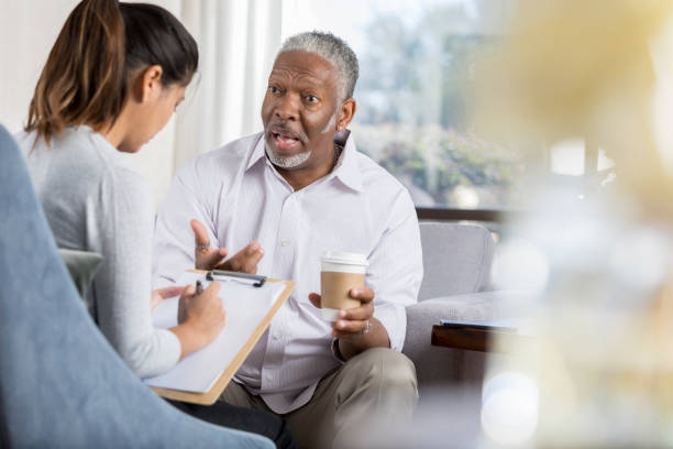 istock Senior man in serious conversation with therapist 1032209856