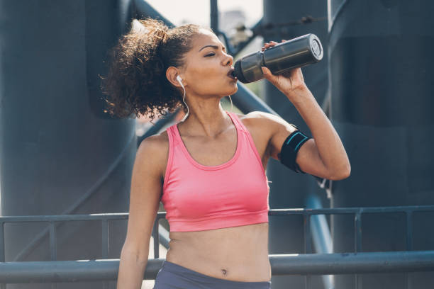 istock Beautiful african-american woman drinking water after training 1032210406