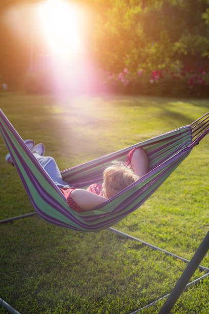 istock beautiful girl resting in a hammock at sunset 1032222196