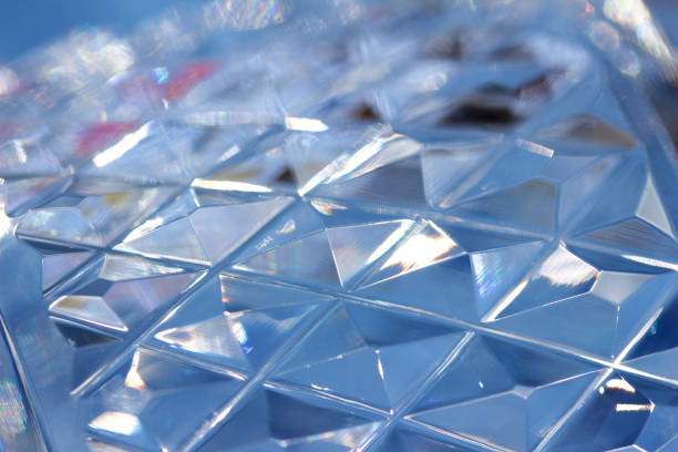 Defocused macro abstract of diamond pattern cut lead crystal glass Defocused macro abstract of shimmering diamond pattern cut lead crystal glass with blue reflected color. lead cut glass crystal stemware stock pictures, royalty-free photos & images