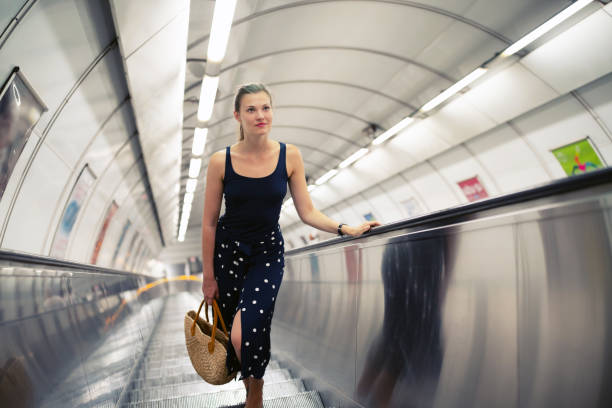istock Young beautiful woman on an escalator 1032239020