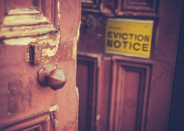 Eviction Notice On Door Grungy Old Door With A Yellow Eviction Notice eviction photos stock pictures, royalty-free photos & images