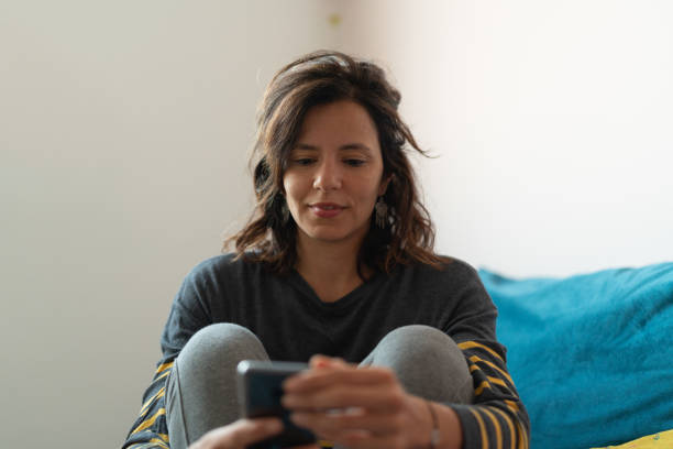 istock Mature Woman Using Her Smartphone Sitting on the Sofa At Home - Portrait 1032269014