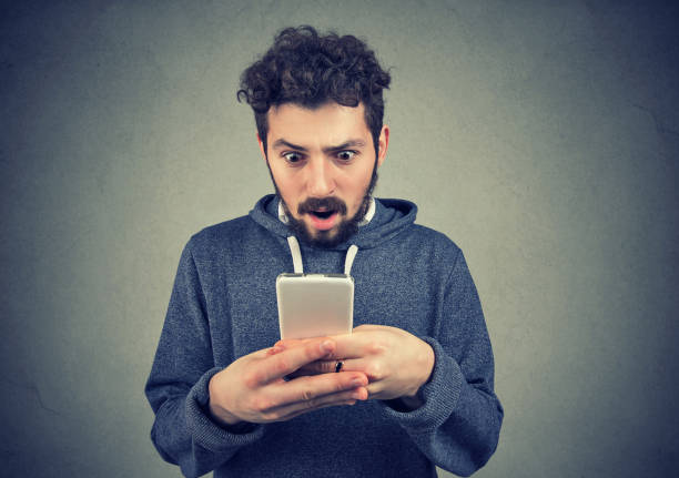 istock anxious young man looking at mobile phone seeing bad news 1032272450