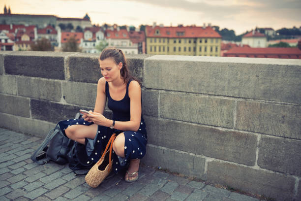 istock Young woman with mobile phone on the Charles Bridge 1032275696