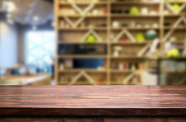 istock Close-Up Of Empty Wooden Table Against Shelves 1032276758