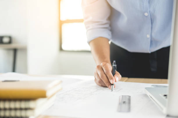 istock Midsection Of Male Architect Drawing On Paper At Desk 1032285046