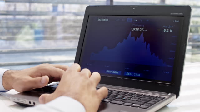 Man using his laptop in the office to check the value of cryptocurrency