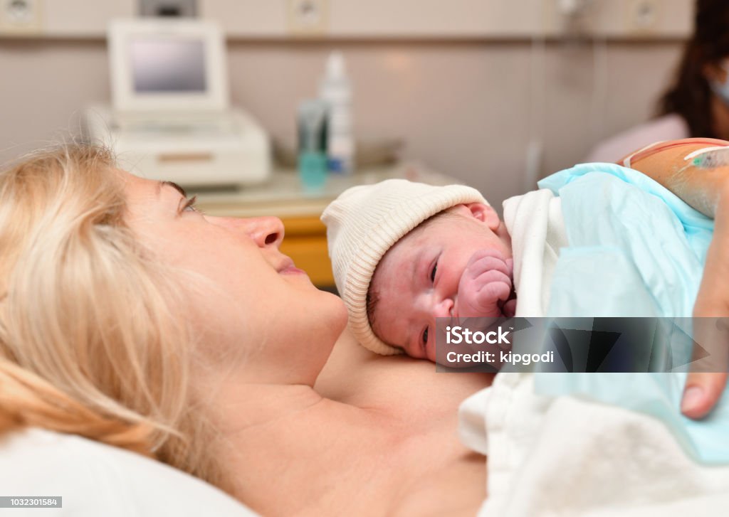 Mom and newborn baby skin to the skin after birth in the hospital Mom and newborn baby skin to the skin after birth Skin Stock Photo