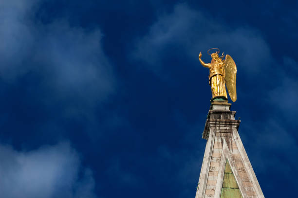Golden angel statue with blue sky, at the top of Saint Mark Bell Tower in Venice, erected in 1820 and designed by venetian artist Luigi Zandomeneghi
