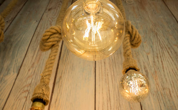 istock Hanging light bulbs over weathered wooden background 1032330138