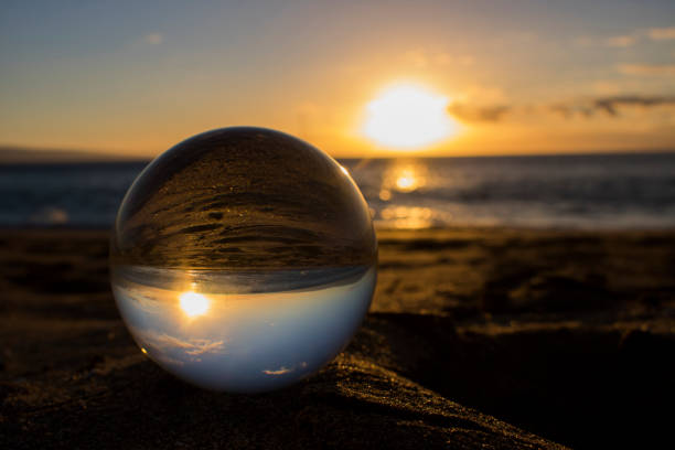 istock Sunset on Beach with Orange Sky and Sand through Glass Ball 1032359054