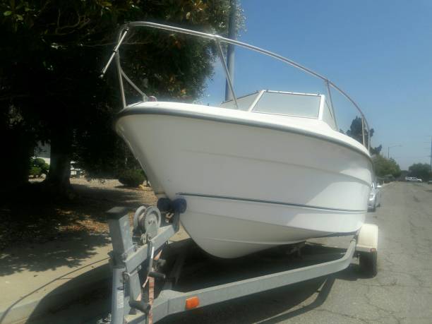 istock White boat parked on roadside in neighborhood. 1032374740