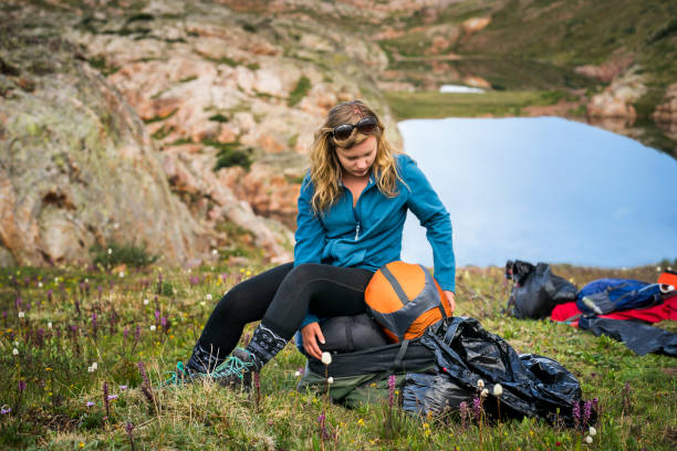 istock Teen stuffing compression sacks into bags on camping trip in Colorado 1032402686