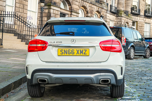A white Mercedes GLA 250 is parked on a cobbled street in the New Town district of downtown Edinburgh, Scotland, UK.