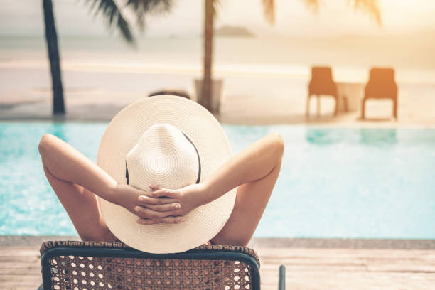 femmes asiatiques relaxantes dans la piscine vacances d’été sur la plage - hammock beach vacations tropical climate photos et images de collection