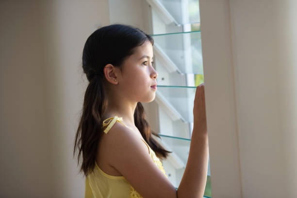 istock Mixed Race Child looking out the window 1032433764