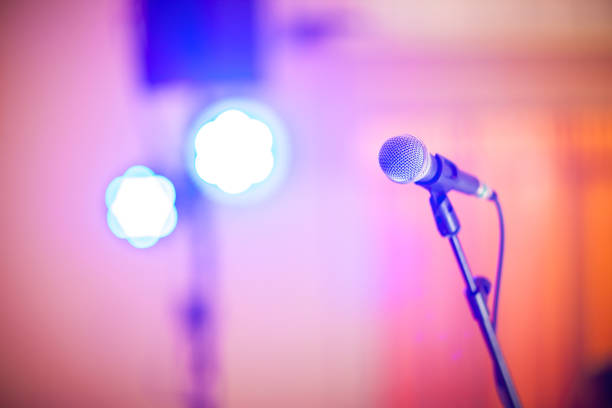 istock microphone in concert hall or conference room soft and blur style for background.Microphone over the Abstract blurred photo of conference hall or seminar room background. 1032448042