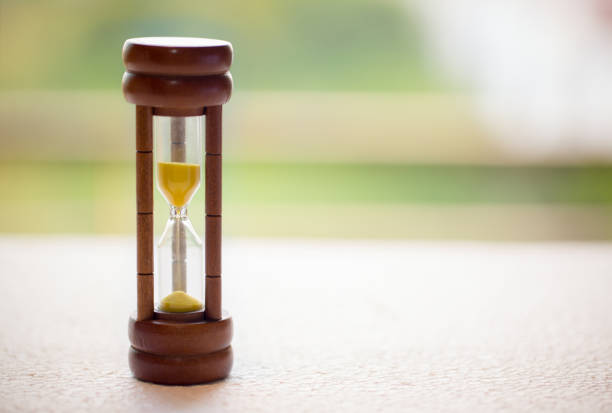 istock Close up wooden hourglass on table with motion blur background, image for background, wallpaper, copy space. Vintage and retro style. 1032451216