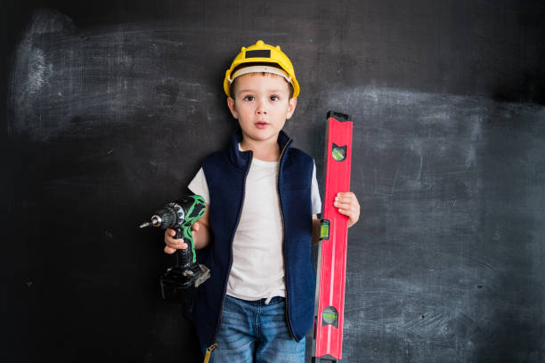 istock Young boy's standing with screwdriver near blackboard. Young builder. Creative design concept for 2019 calendar. 1032451734