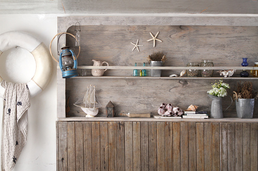 the vintage wooden wall is a shelf and decorated with a lot of stuff in marine style