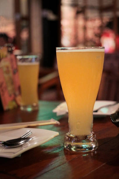 two glasses of pilsner beer on the red table