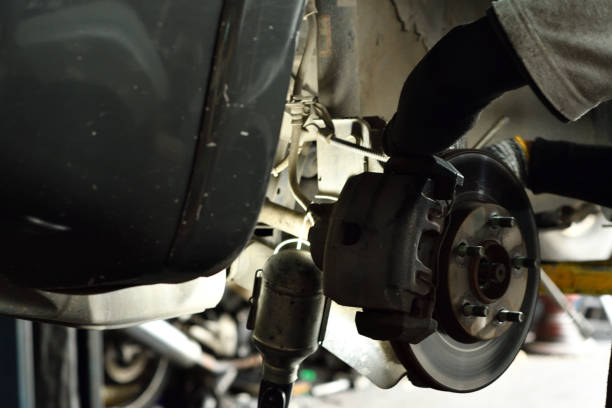 istock Technician action to maintenance disc break car in garage. 1032454752