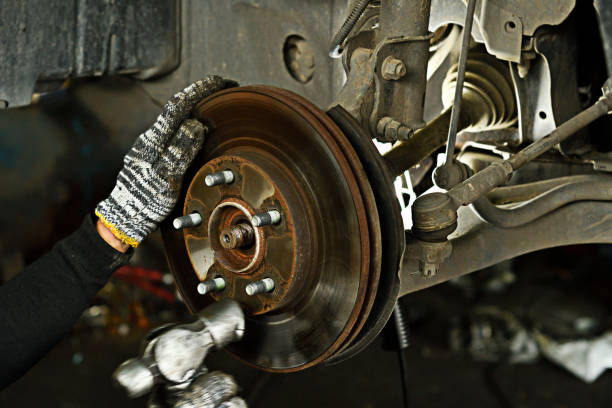istock Technician use steel hammer for action to maintenance disc break car in garage. 1032454772