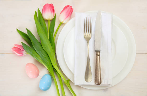 istock Easter table setting with pink tulips on white wooden background. Top view 1032454842