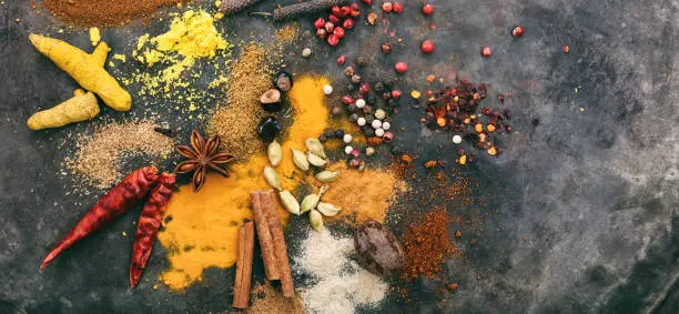 Photo of Variety of colorful spices on metal rusty background, top view, copy space, banner