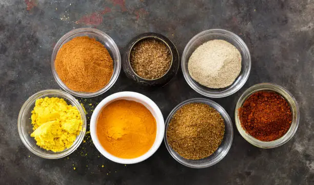 Photo of Variety of colorful spices on metal rusty background, top view