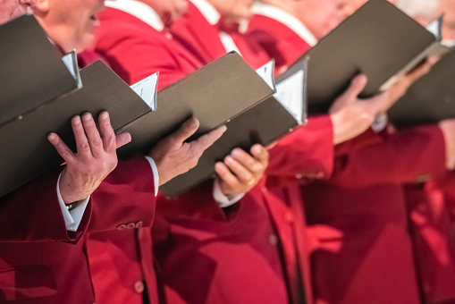 Rochester, England -  July 2018 : Close up of mens choir members holding singing book while performing in a cathedral in Kent, UK