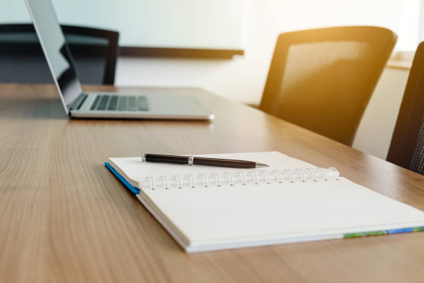 istock Pen on notepad and laptop and for agenda kept on table in empty corporate conference room. selected focus on pen and notepad. 1032469058