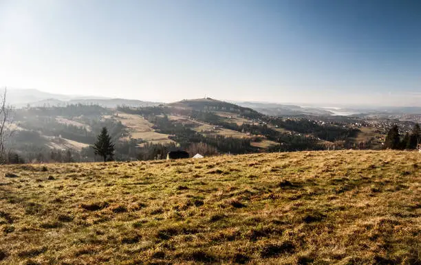 view from Tyniok hill in autumn Beskid Slaski mountains in Poland with hills, villages and blue sky