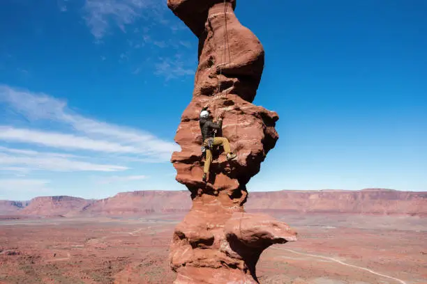 Rock Climber ascending "Stolen Chimney" on Fisher Towers, commonly called "Ancient Arts".