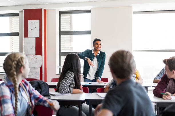 istock Teenage girl explaining classmates in classroom 1032469930