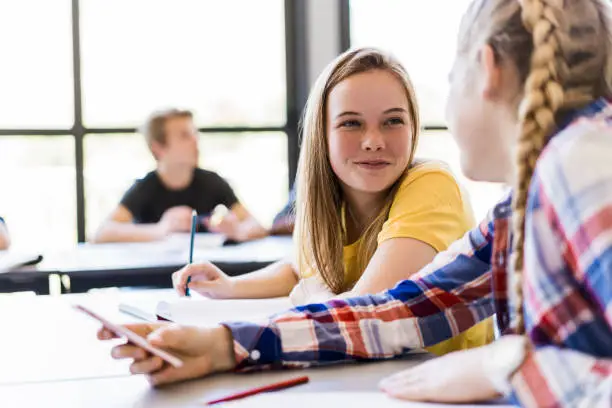 Photo of Female friends talking in classroom