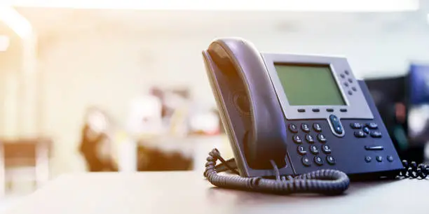 Photo of close up soft focus on telephone devices at office desk for customer service support concept