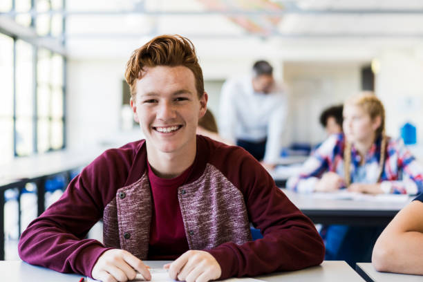 istock Portrait of male student smiling in classroom 1032472594