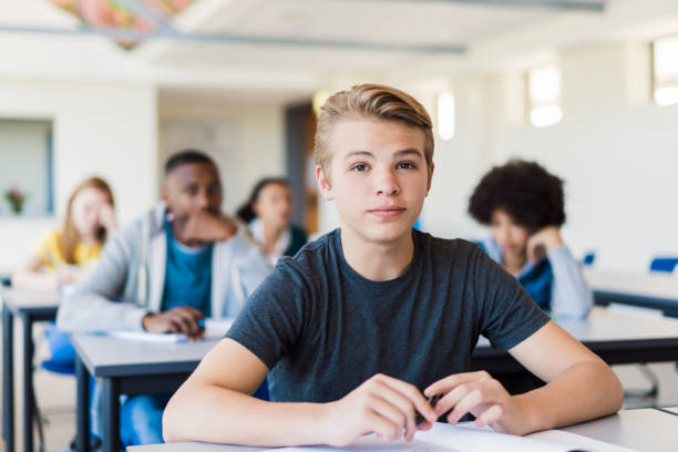 istock Portrait of male student sitting in classroom 1032472702