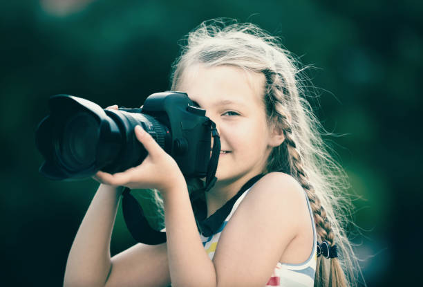 istock friendly female child taking pictures with camera in park 1032473098
