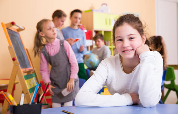 istock Smiling schoolgirl in classroom during break 1032479066