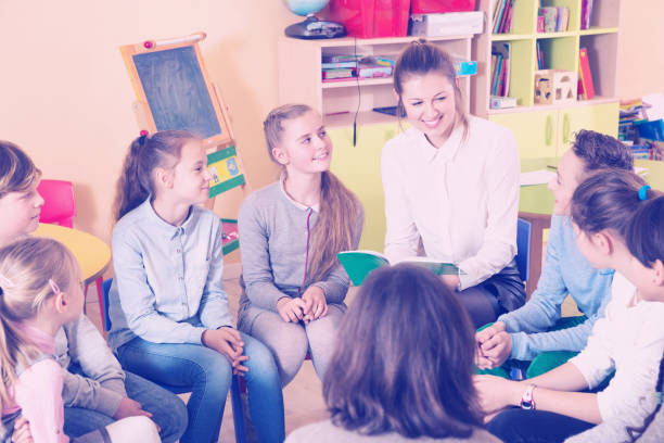 istock children sitting and listening teacher 1032479084