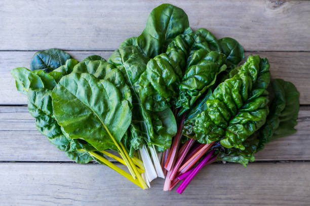 acelga orgánica del arco iris: libre aerosol de vegetales de hojas verdes en el arreglo del ventilador sobre fondo de madera rústica - vegetal con hoja fotografías e imágenes de stock