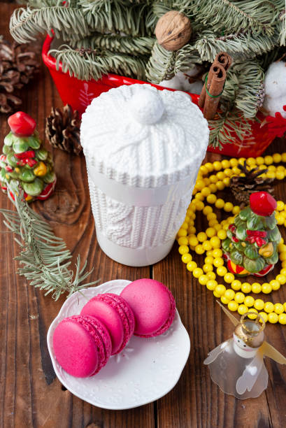 istock White cup and pink macaroons with christmas decorations on wooden background 1032483094