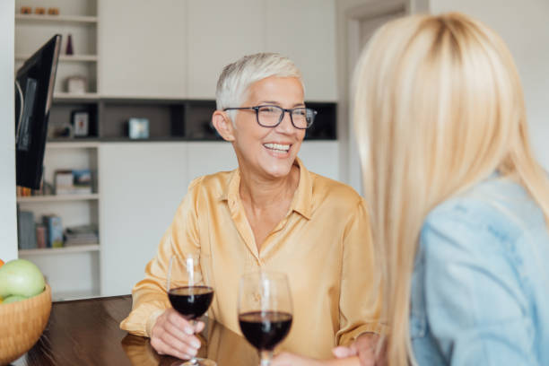 istock Older woman drinking red wine with a friend 1032493038