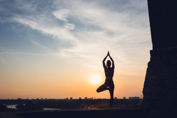 istock Woman practicing yoga outdoors. Summer sunset 1032495698