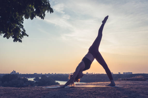 istock Woman practicing yoga outdoors. Summer sunset 1032495704